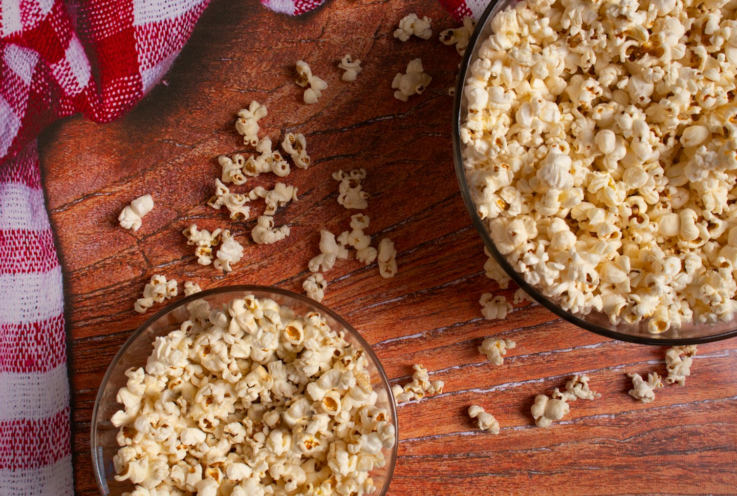 Zwei Schüsseln Popcorn auf einem Holztisch.